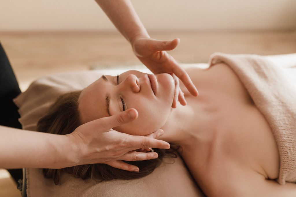 Craniosacrale Therapie Bild zeigt Frau, wie Sie eine craniosacrale Therapie mit den Händen erhält